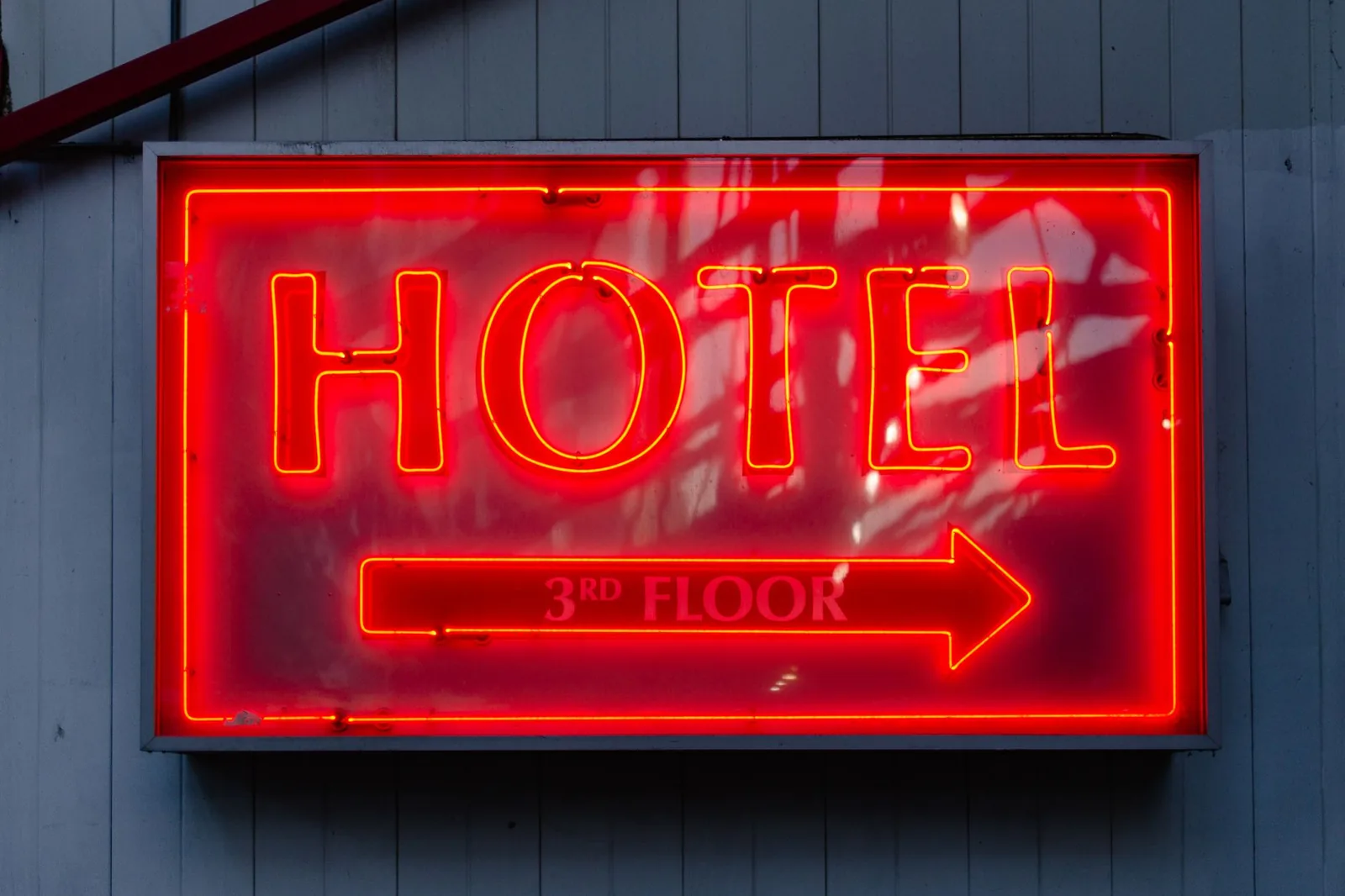 Traveler comparing a hotel's own website with a third-party booking site on a laptop and phone